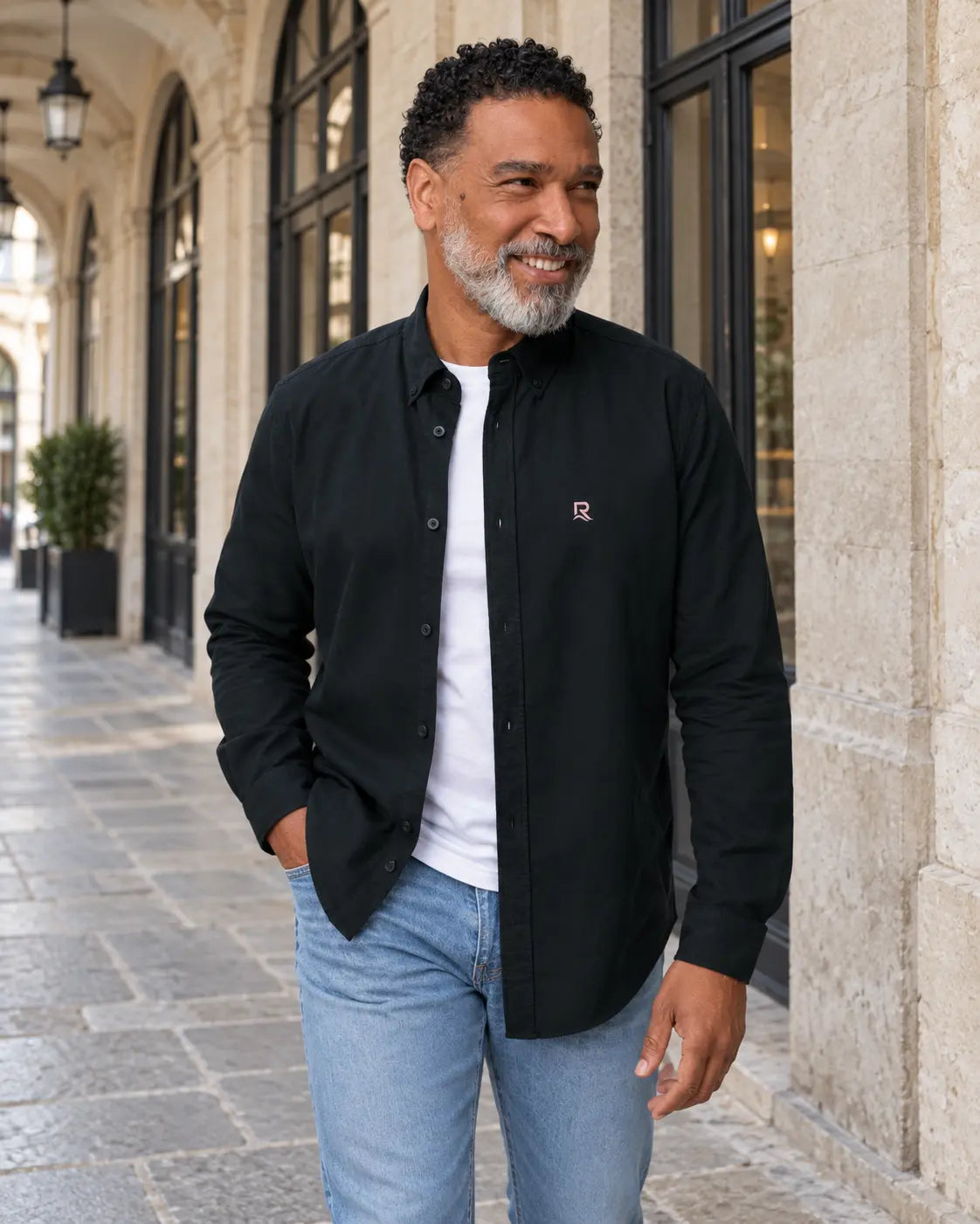Chemise Oxford homme RIVHEX noir portée, broderie côté cœur, passage urbain
