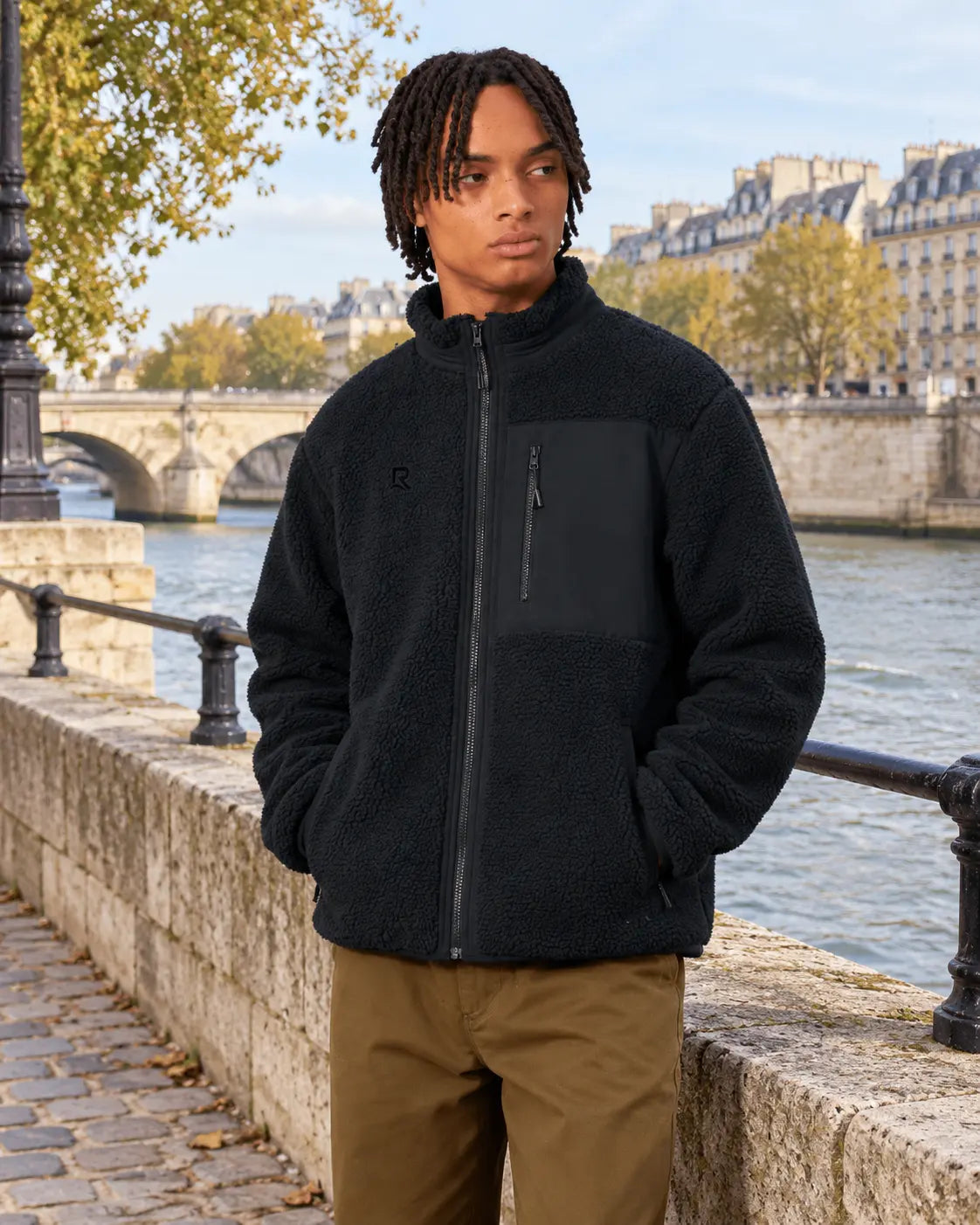 Veste Sherpa unisexe RIVHEX Le Refuge noir, homme sur un quai