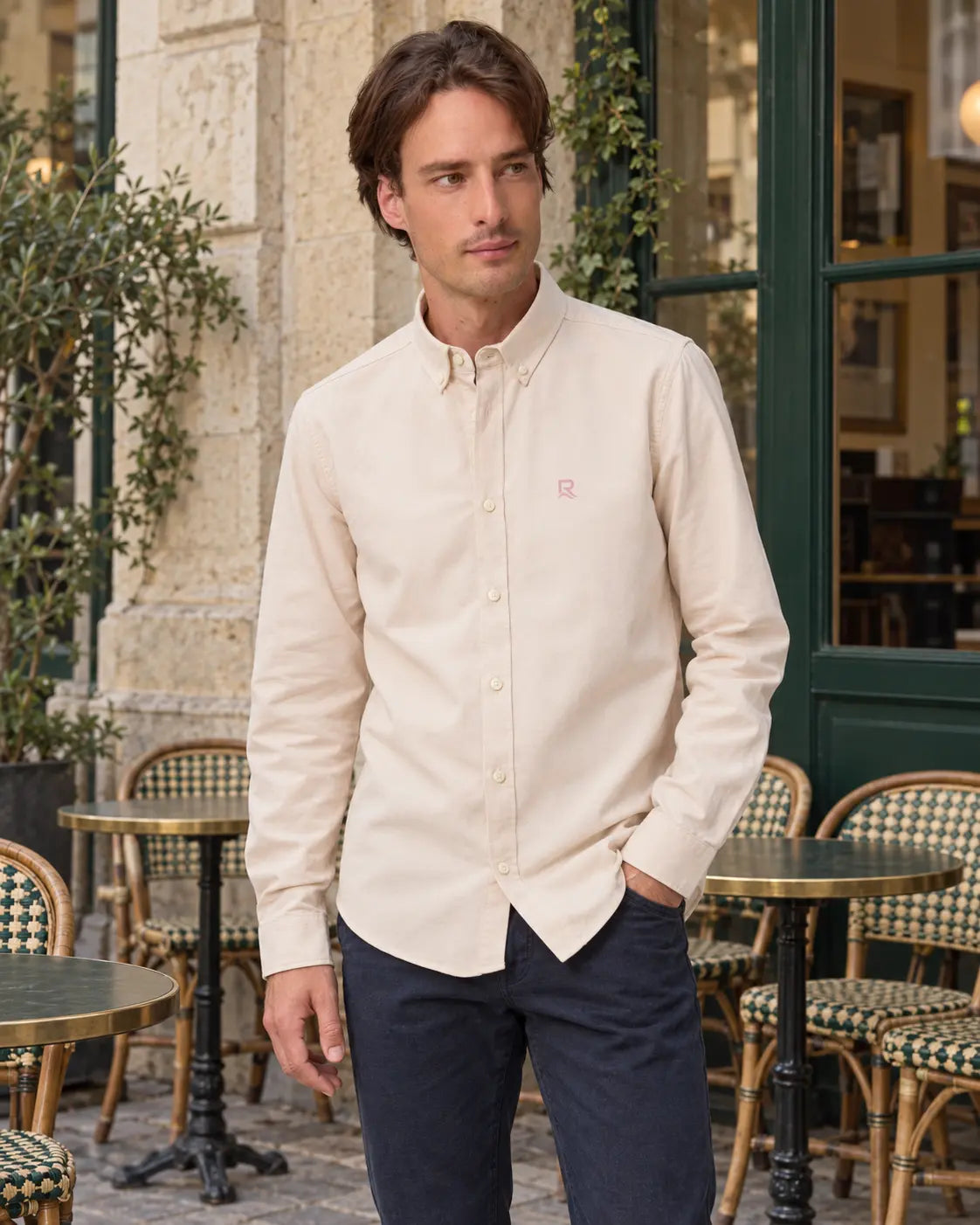Chemise Oxford homme RIVHEX crème portée, broderie côté cœur, terrasse de café