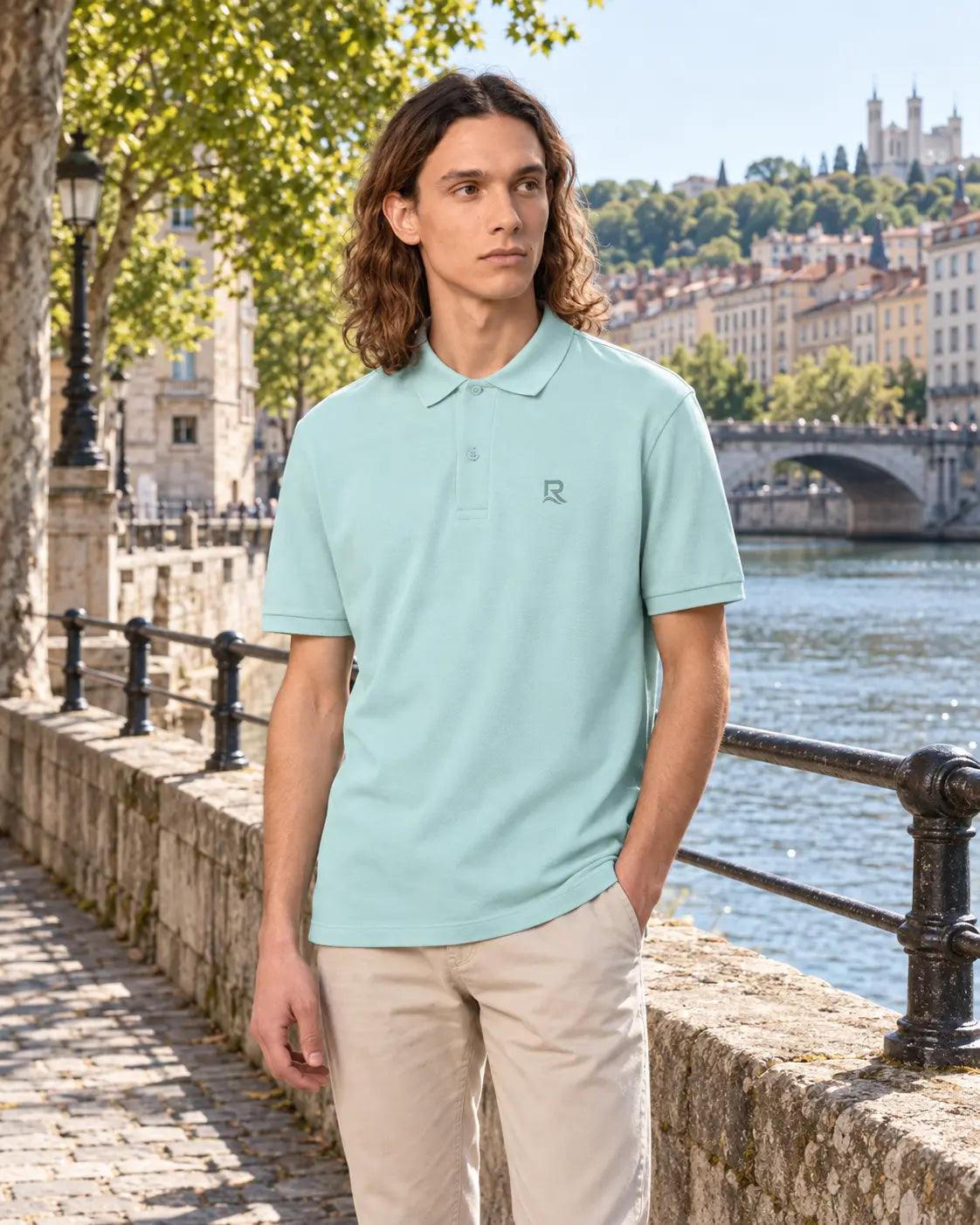 Polo homme RIVHEX bleu caraïbe porté, broderie ton sur ton, quai en ville