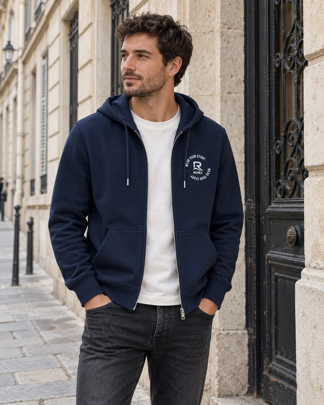 Veste à capuche Urban-Riv RIVHEX bleu marine portée en ville, ouverte sur un t-shirt blanc, logo blanc côté cœur
